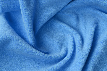 The blanket of furry blue fleece fabric. A background of light blue soft plush fleece material with...