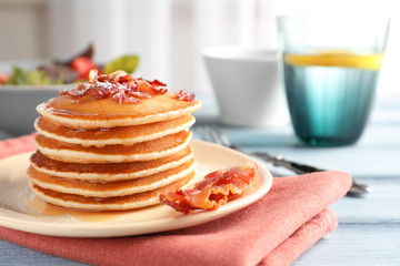 Tasty breakfast with pancakes and bacon on table