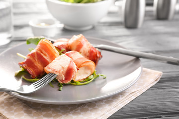 Plate with bacon wrapped chicken nuggets on table, closeup