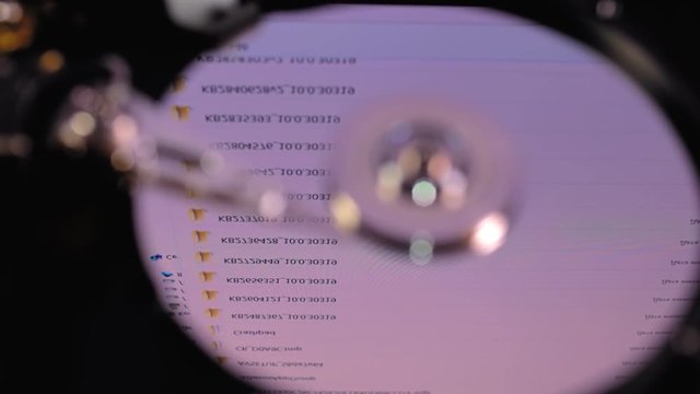 The hdd  working, the head moves over the disk, operating system files recorded on this disk are reflected on its surface. Top view. Macro. Closeup