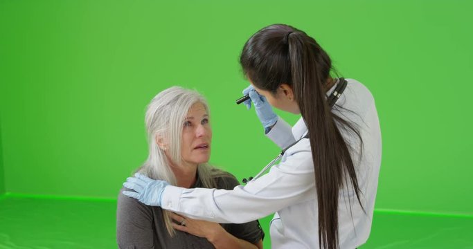 An EMT offers roadside help to a elderly woman on green screen. On green screen to be keyed or composited. 