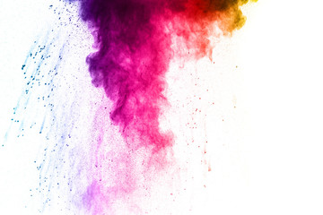 The explosion of multi colored powder. Beautiful powder fly away. The cloud of glowing color powder on white background