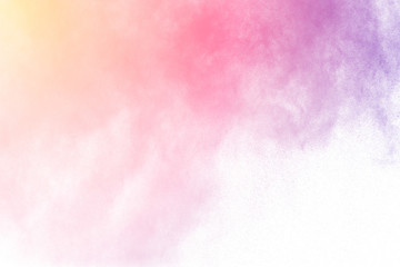 The explosion of multi colored powder. Beautiful powder fly away. The cloud of glowing color powder on white background