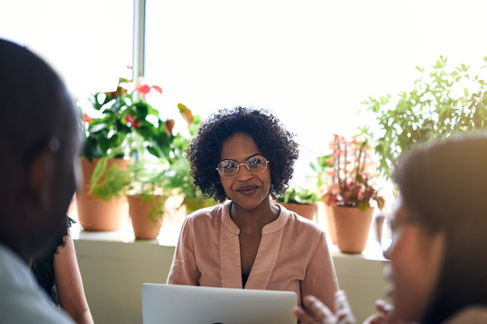 Smiling African businesswoman meeting with colleagues in an offi