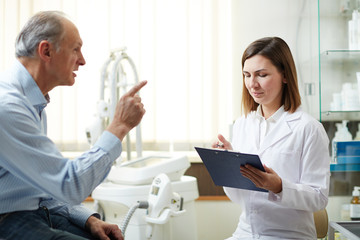 Fototapeta premium Senior patient telling his doctor about strange symptoms that occurred not so long ago