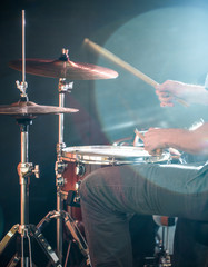 man plays the drum, flash of light, a beautiful light in the background with copy space
