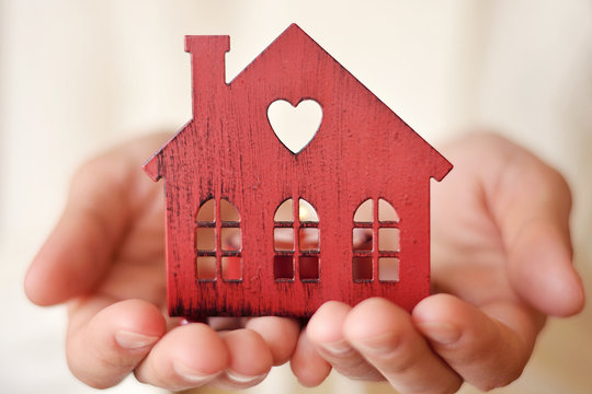 Warm and cozy miniature house in female hands. Care and love. 