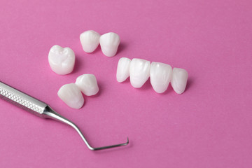 Zircon dentures with dental tool on a pink background - Ceramic veneers - lumineers