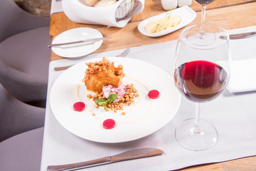 Polish-Lithuanian traditional spit cake ('tree cake') -sekacz (polish) or sakotis (lithuanian) with ice-cream, roasted nuts and raspberry jelly decorated wtih fresh mint served in a restaurant
