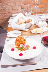 Polish-Lithuanian traditional spit cake ('tree cake') -sekacz (polish) or sakotis (lithuanian) with ice-cream, roasted nuts and raspberry jelly decorated wtih fresh mint served in a restaurant