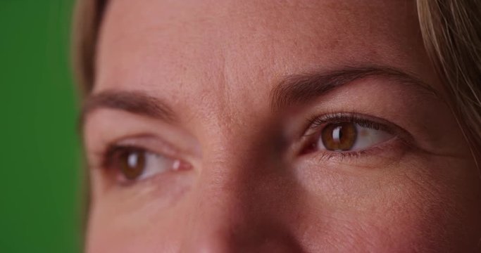 Extreme close up of Caucasian woman's eyes on green screen. On green screen to be keyed or composited.
