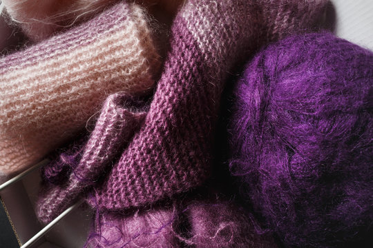 Purple and pink yarn and knitting needles.