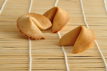 Three fortune cookies displayed on a bamboo background