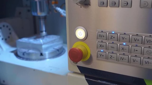 Milling machine carves detail under computer control. The display is visible the program code and buttons flash