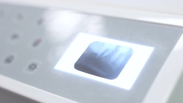 Dentist puts X-ray on the screen and presses the button for the backlight