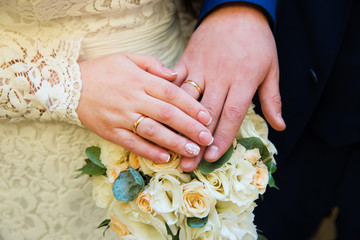 Bride and groom hands with wedding rings