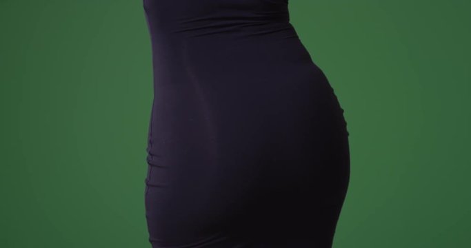 Sexy woman in a tight black dress dancing from behind on green screen. On green screen to be keyed or composited. 