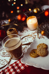 Obraz na płótnie Canvas Cup of coffee, candle and cookies on table with winter and christmas decorations. 