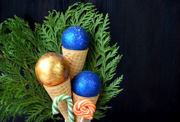 Christmas balls in waffle cones. Thuja branches in the background