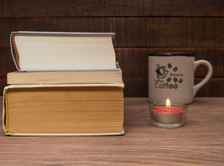 Books and a cup of coffee on a wooden table