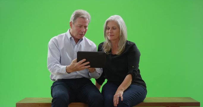Mid aged white couple looking at tablet computer