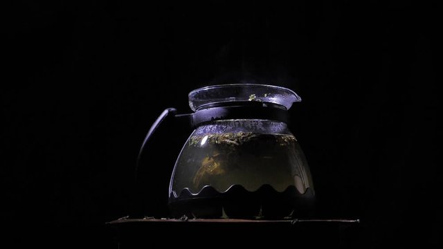 Teapot with a hot tea. Lemons dropped into a teapot.