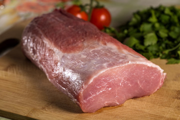 Raw pork chop meat on wooden cutting board
