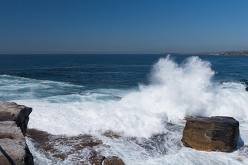 Tosende Brandung spritzt über Felsen in der Bucht