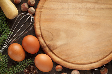 Fototapeta na wymiar Culinary baking background with cutting board, eggs, whisk, nuts.