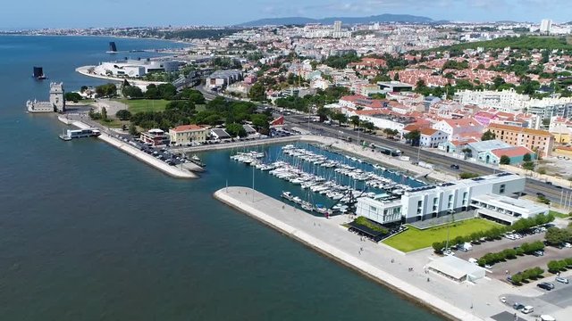 Aerial bird view Lisbon marina and Torre de Belem in background showing marina and sail yachts located at the Tagus river bank in further background showing Tower of Belem top 10 tourist attraction 4k