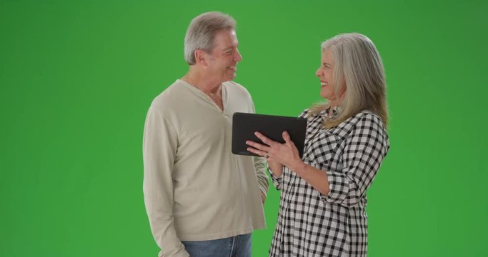 Portrait of senior couple looking at handheld tablet device