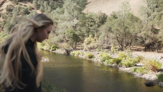 gimbal shot of teen girl walking in on merced river