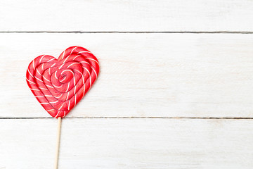Sweet candy in the shape of heart on a wooden background. Copy space