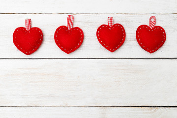 Red hearts of felt on a white wooden background. Valentine concept