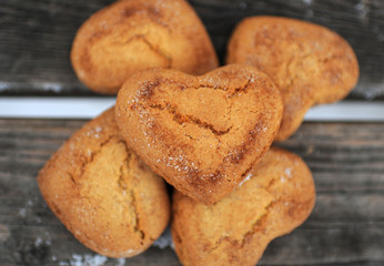 Homemade cookies with sugar and cinnamon in the form of hearts on a wooden background