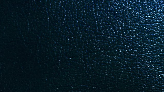 Structure, texture and surface pattern of black, blue skin. Light moves around the sample. Macro. Closeup 
