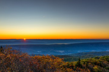 Obraz premium Morning dark sunrise with sky and golden yellow orange autumn foliage in Dolly Sods, Bear Rocks, West Virginia with overlook of mountain valley