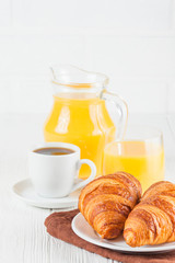 Freshly baked croissant, orange juice, fresh fruits, jam on white wooden background. French breakfast. Fresh pastries for morning. Delicious dessert. Closeup photography. Vertical banner