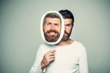 Hipster with serious and scary face hold portrait nameplate.