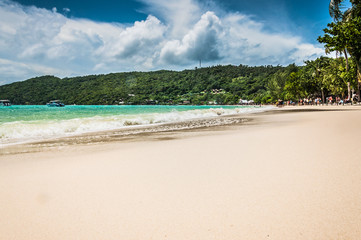Spectacular view on the ocean from a sandy beach with Blue sky and white clouds on the background