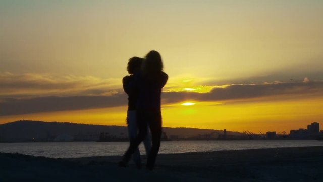 Two women friends on the beach at sunset