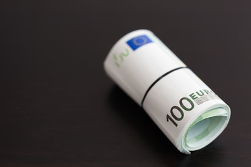Roll of one hundred euro bills. Shallow dof