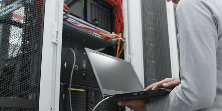 male technitian using computer in data center