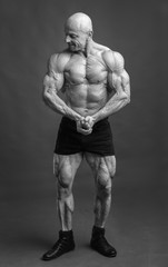 Naklejka premium Athlete in front pose. Bodybuilder showing muscles and motivating to training.
