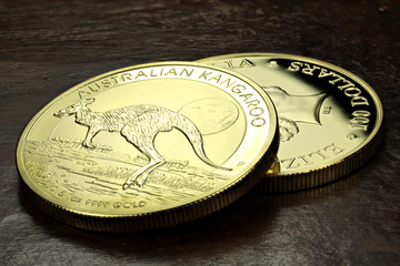 1 ounce Australian Kangaroo gold bullion coins on wooden background