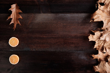 autumn leaves with decorative candles on wooden background flat view copy space