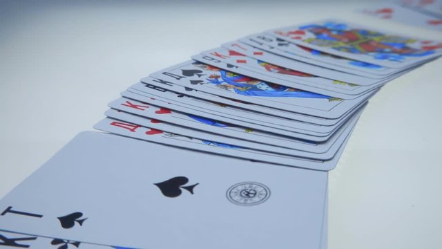 Hand lay out playing cards on a white luminous surface. Macro. Closeup. Slow mo, slo mo, slow motion, high speed camera, 240fps, 250fps