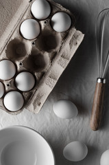 Fototapeta na wymiar White eggs in an egg carton. White linen tablecloth background.