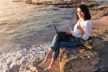 freelancer girl on the beach with her thumb up