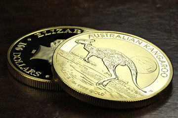 1 ounce Australian Kangaroo gold bullion coins on wooden background